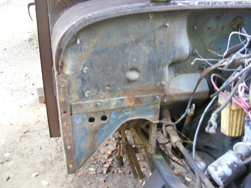 Close-up of a vehicle's rusty firewall and engine bay with exposed wiring