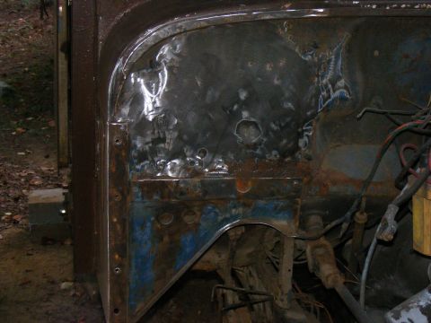 1978 Ford Bronco - Close-up view of a heavily rusted and modified vehicle engine bay, showing exposed metal and wiring.