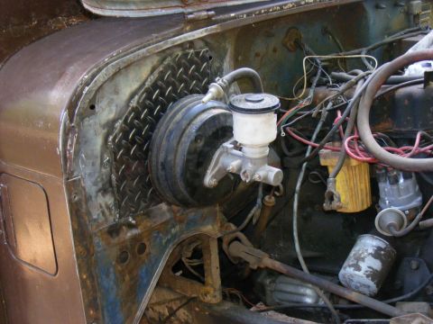 1978 Ford Bronco - Close-up of the engine bay, focusing on the brake booster and master cylinder assembly.