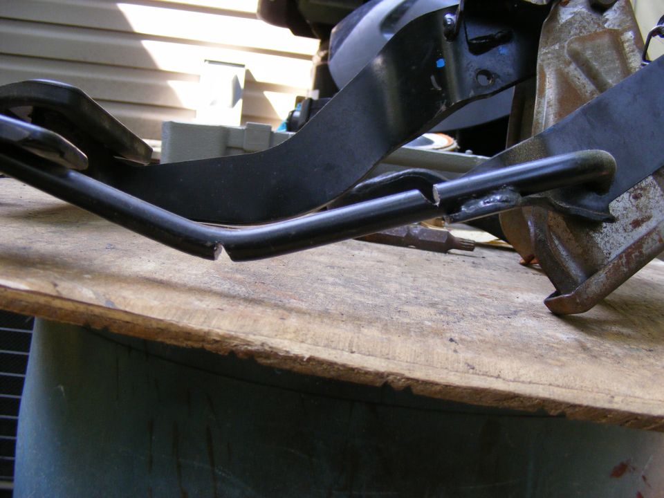 Close-up of a bent and broken metal bracket, possibly from a vehicle's interior