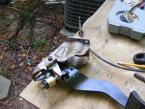 1978 Ford Bronco - A clutch pedal assembly with a sensor is shown on a workbench.