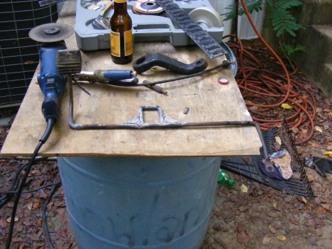 1978 Ford Bronco - Tools and a metal bracket are laid out on a wooden board, ready for work.