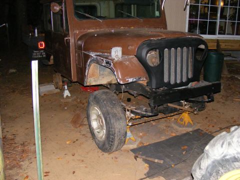 1978 Ford Bronco - This Jeep CJ-5 is undergoing repairs, with its front end partially dismantled and raised on jack stands.