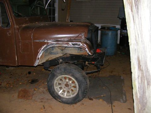 1978 Ford Bronco - This brown SUV's front end is visible, showing a wheel and fender area that looks like it's being worked on.