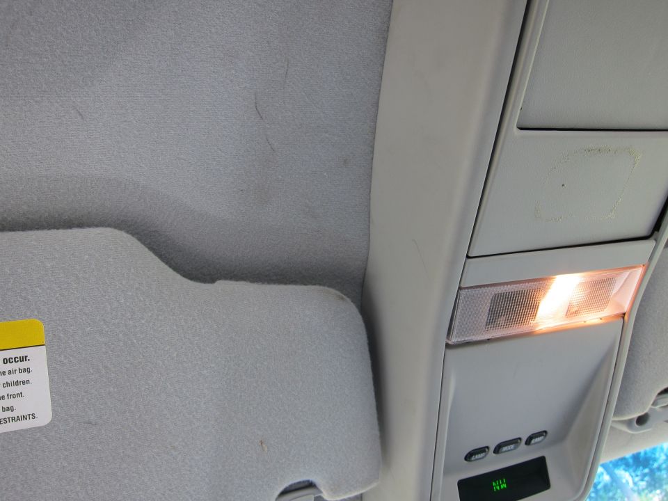 Interior overhead console with illuminated light and buttons