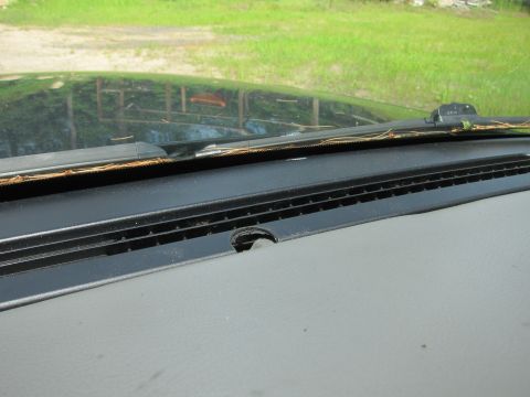 2001 Ford Crown Victoria - View from inside a vehicle, showing the dashboard and windshield with reflections of the outdoor environment.