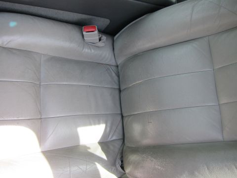2001 Ford Crown Victoria - The interior of a car shows the detail of the gray leather seats and a seatbelt.