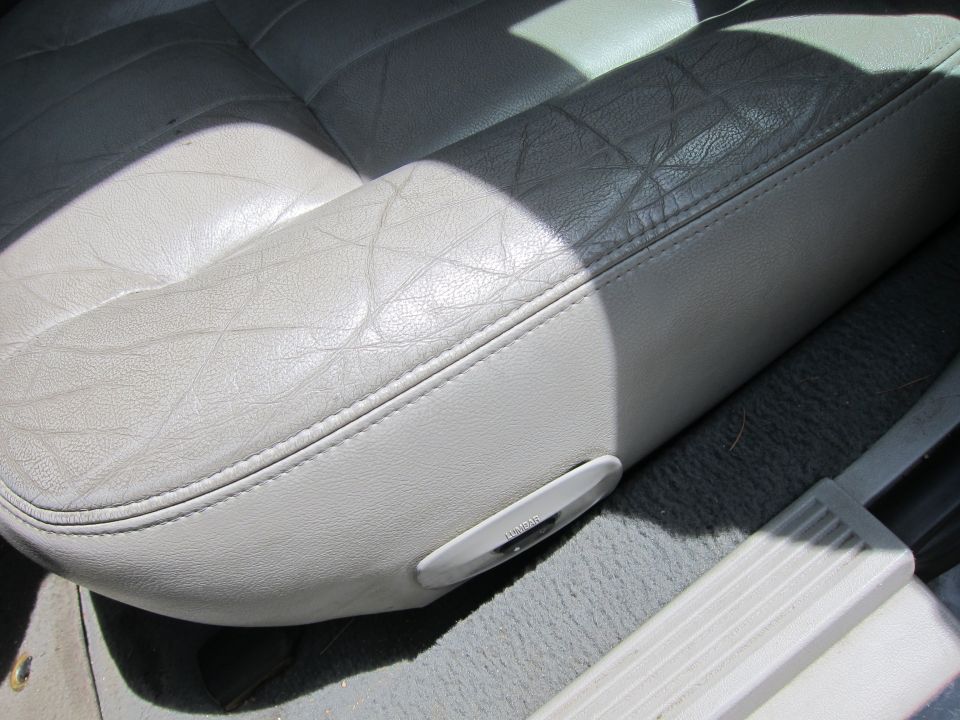 Light gray leather car seat with diamond stitching and a power seat adjustment control