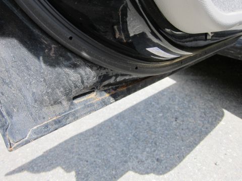 2001 Ford Crown Victoria - The interior door sill of a black 2001 Ford Crown Victoria shows signs of rust and wear.