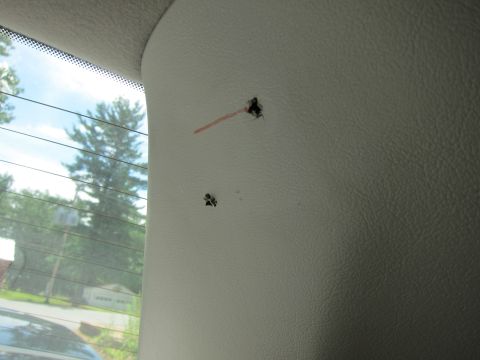 2001 Ford Crown Victoria - Damage to the interior panel of a vehicle is visible, with two holes and a red marking.