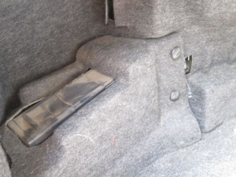 2001 Ford Crown Victoria - Interior view of a vehicle's trunk, showing gray carpeting and a black plastic component.