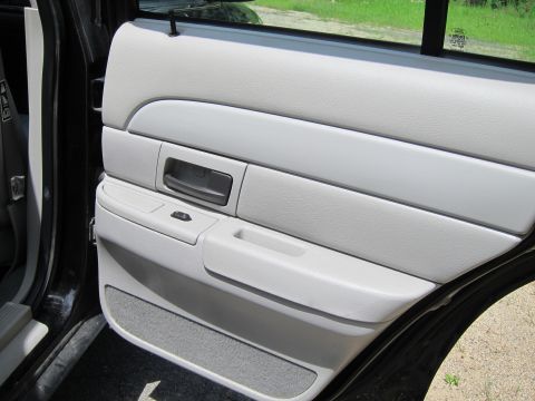 2001 Ford Crown Victoria - Close-up of a car's interior door panel, showing the armrest and window controls.