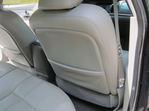 2001 Ford Crown Victoria - The interior of a car shows the back seats and a center console with storage.