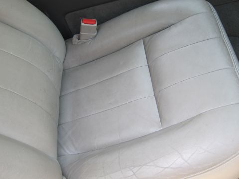 2001 Ford Crown Victoria - Interior view of light gray leather car seats and a red seatbelt buckle.