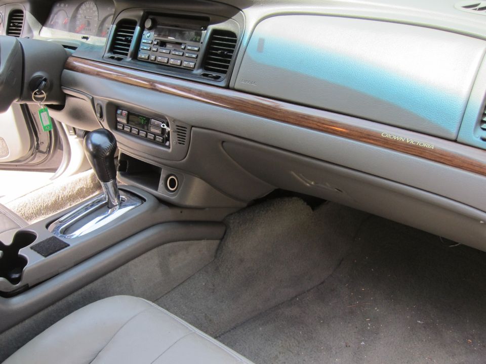 Interior shot of a 2001 Ford Crown Victoria, showing dashboard, center console with gear shifter, and passenger seat