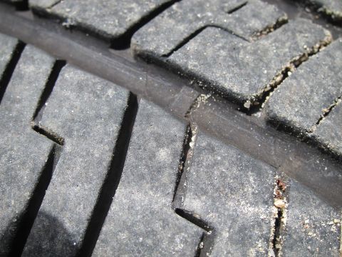 2001 Ford Crown Victoria - Tire tread detail shows wear and accumulated sand.