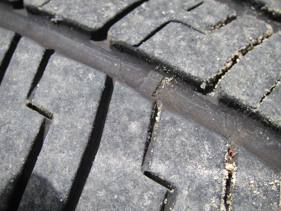 Close-up of tire tread with sand in the grooves