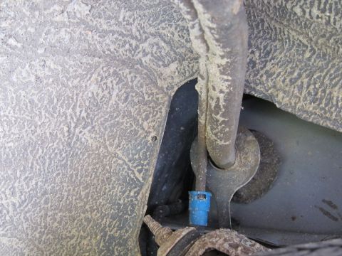 2001 Ford Crown Victoria - Detail of a vehicle's undercarriage, showing a blue connector and associated tubing.
