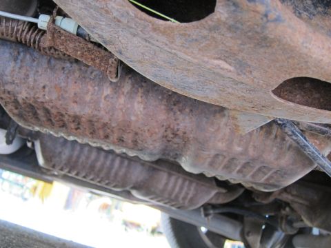 2001 Ford Crown Victoria - The heavily rusted undercarriage of a vehicle reveals its exhaust system and suspension components.