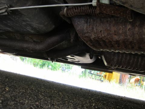 2001 Ford Crown Victoria - The underside of a vehicle is visible, with focus on the exhaust system and rusty components.