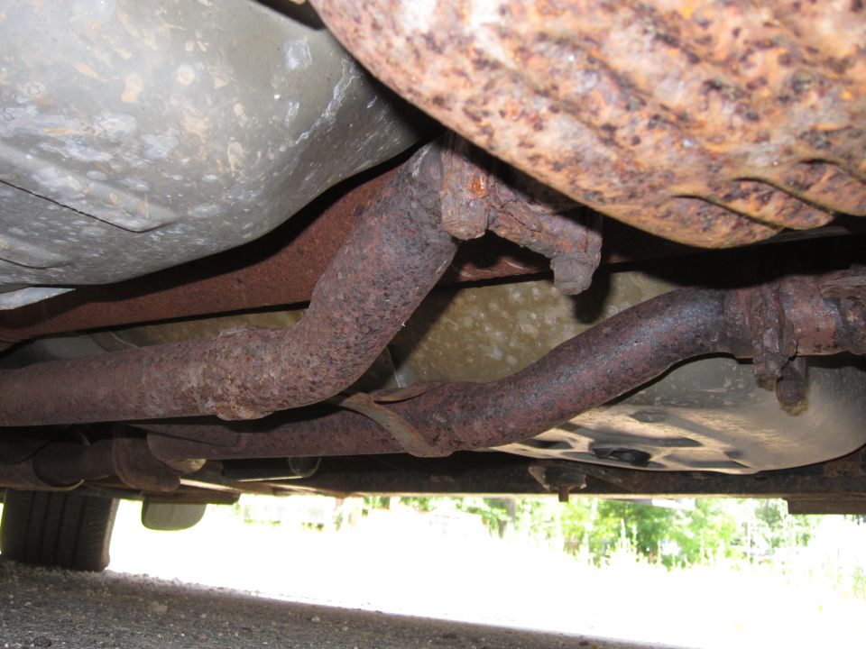rusted exhaust pipes and undercarriage of a vehicle