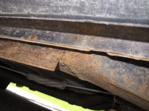 2001 Ford Crown Victoria - The undercarriage of the vehicle shows significant rust and corrosion on its structural components.