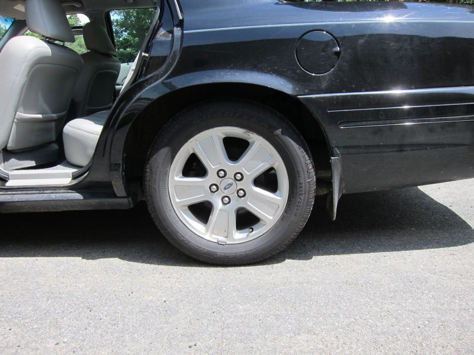 2001 Ford Crown Victoria side view, black sedan rear wheel and interior
