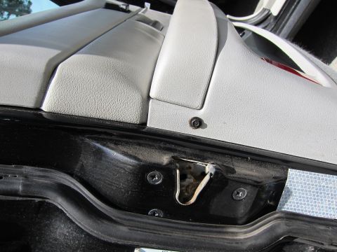 2001 Ford Crown Victoria - Close-up view of the interior door latch mechanism, showing screws and a black rubber seal.