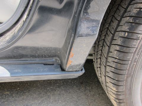 2001 Ford Crown Victoria - Rust is visible on the lower part of a car's door sill near the tire.