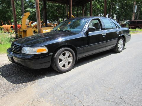 2001 Ford Crown Victoria - Black 2001 Ford Crown Victoria sedan parked outdoors on a cracked asphalt surface.