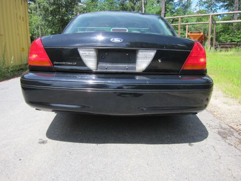 2001 Ford Crown Victoria - Rear view of a black 2001 Ford Crown Victoria, showing the taillights and 'Crown Victoria LX' badging.