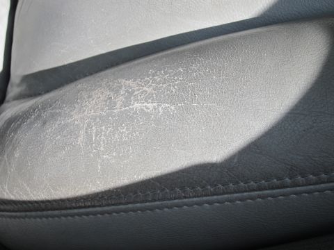 2001 Ford Crown Victoria - Cracked leather upholstery on a car seat shows significant wear.