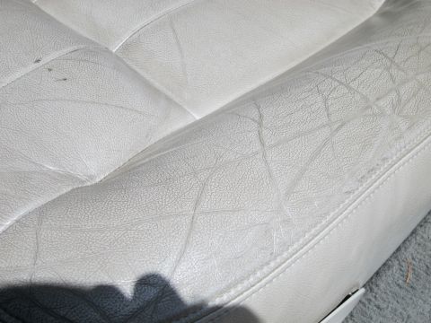 2001 Ford Crown Victoria - Close-up of a worn white leather car seat interior.