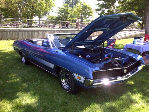 1971 Ford Ranchero - A blue convertible is parked on the grass with its hood open, revealing the engine bay.