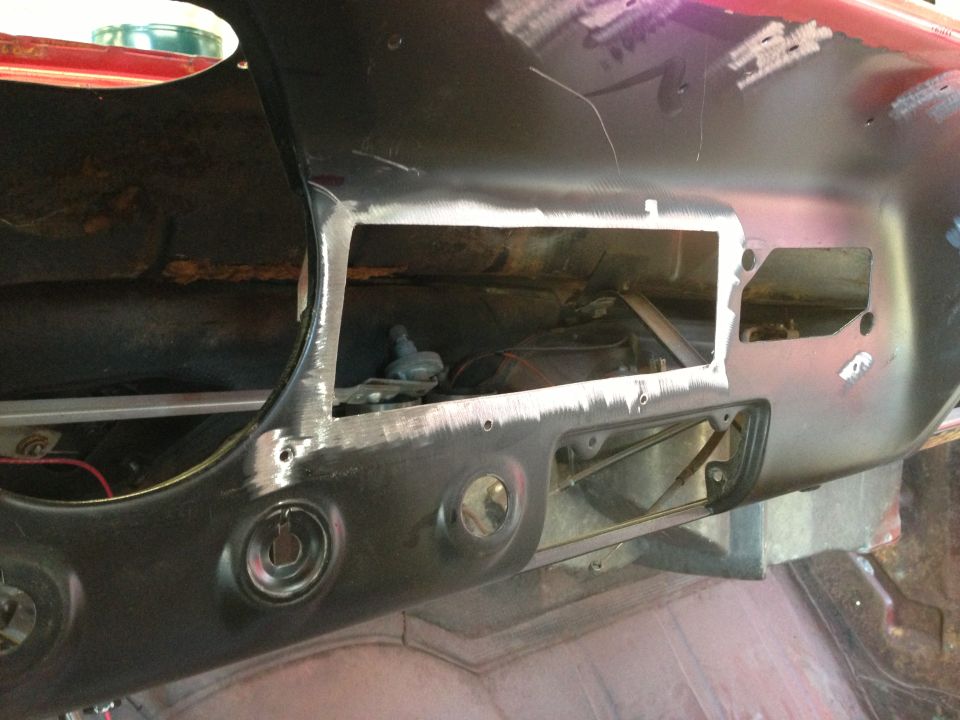 Car dashboard being prepped for paint, showing cutouts for radio and vents