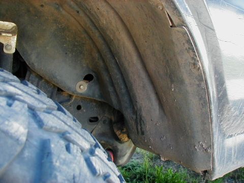 1981 Ford Bronco - The inner fender well shows dirt and rust, with a portion of the tire visible.
