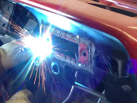 1964 Ford Fairlane - A person is welding a metal panel inside a vehicle's interior.