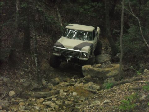 1979 Ford F-150 - This lifted Ford F-150 navigates a challenging, rocky trail through a wooded area.