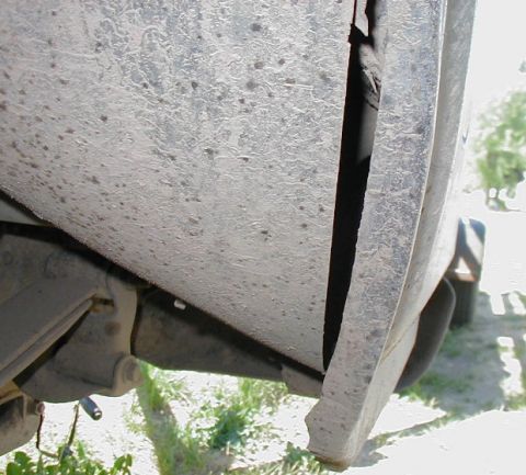 1981 Ford Bronco - Detail shot of the fender and undercarriage of a vehicle, showing suspension parts.