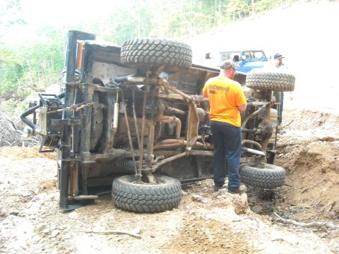 1979 Ford F-150 - Pickup truck overturned off a dirt road with assistance from another vehicle.