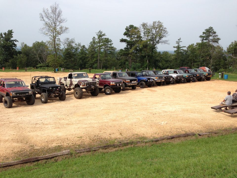 Line of off-road vehicles parked on dirt lot