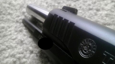 2000 Mercury Grand Marquis - Close-up of a pistol slide and barrel, showing the Taurus logo and serrations.