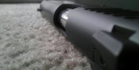 2000 Mercury Grand Marquis - Close-up of a pistol slide and barrel on a textured surface.