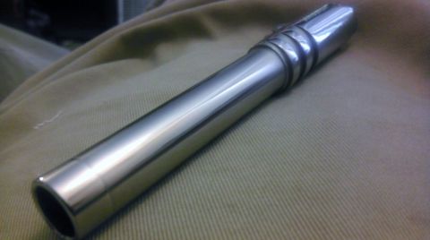 2000 Mercury Grand Marquis - A shiny metal component rests on a textured tan surface.