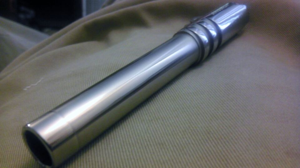 Chrome cylindrical part with ribbed section on tan fabric