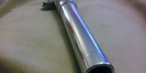 2000 Mercury Grand Marquis - A close-up view of a shiny chrome exhaust pipe resting on a textured fabric surface.