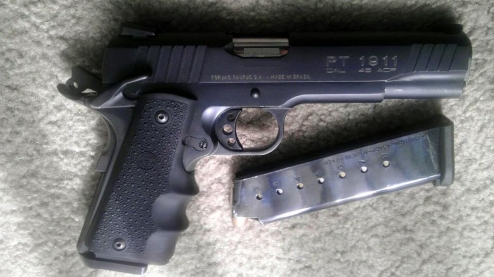 Taurus PT 1911 pistol with a loaded magazine next to it