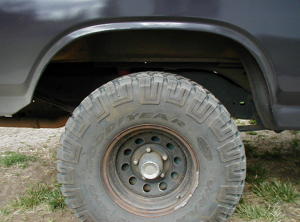 Goodyear mud tire on black steel wheel under gray Bronco rear fender