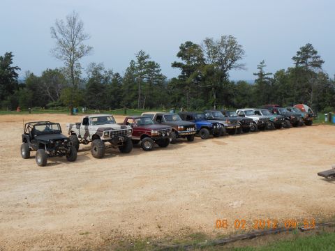 2013 Ford Bronco - Multiple off-road vehicles are parked in a line on a dirt lot.