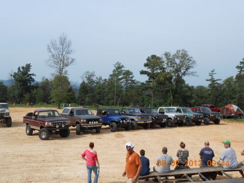 2013 Ford Bronco - A group of off-road vehicles are parked on a dirt lot, with people watching in the foreground.